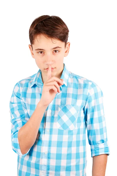 Keep my secret! Serious teen boy in plaid shirt holding finger on lips and looking at camera isolated on white background — Stock Photo, Image