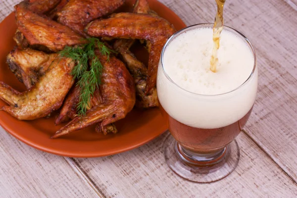 Beer and chicken wings on wooden background — Stock Photo, Image