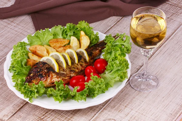 Grilled fish carp served with potatoes, tomatoes cherry and salad — Stock Photo, Image