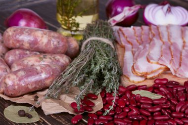 Barbunya, kekik, sosis ve ahşap zemin üzerine pastırma