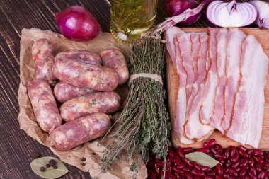 Barbunya, kekik, sosis ve ahşap zemin üzerine pastırma