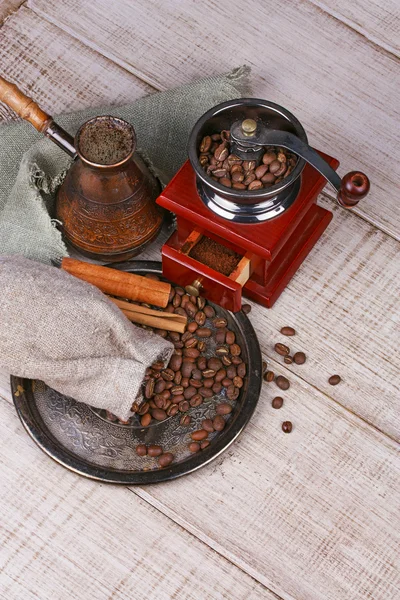 Coffee grinder, turk and cup of coffee on wooden background — Stock Photo, Image