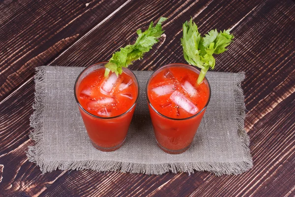 Bloody mary cocktails served with celery on wooden background — Stock Photo, Image