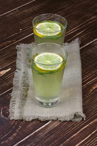 Limonada con limón fresco y estragón sobre fondo de madera — Foto de Stock