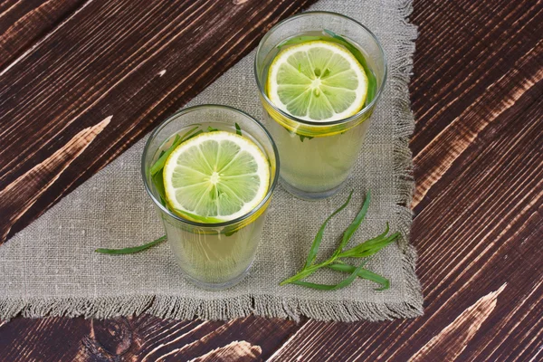 Limonada con limón fresco y estragón sobre fondo de madera — Foto de Stock