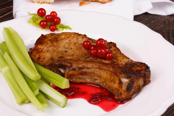 Gebakken pork chop met rode bessen saus en selderij — Stockfoto