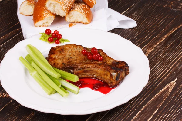 Fried pork chop with red currant sauce and celery — Stock Photo, Image