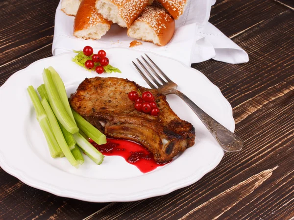 Fried pork chop with red currant sauce and celery — Stock Photo, Image