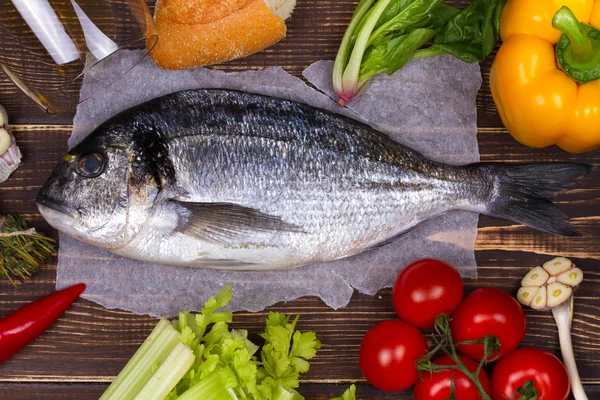 Delicious fresh fish and vegetables on dark vintage background — Stock Photo, Image