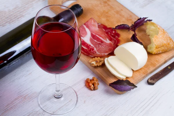 Γυαλί και μπουκάλι κρασί, τυρί και προσούτο. — Φωτογραφία Αρχείου