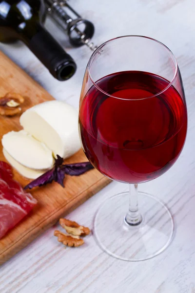 Copa y botella de vino, queso y jamón . —  Fotos de Stock