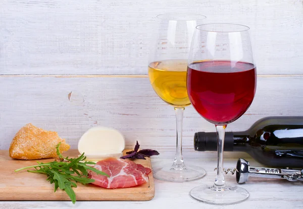 Γυαλί και μπουκάλι κρασί, τυρί και προσούτο. — Φωτογραφία Αρχείου