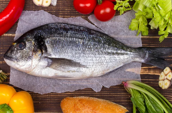 Delicious fresh fish and vegetables on dark vintage background; view from above, studio shot — Stock Photo, Image