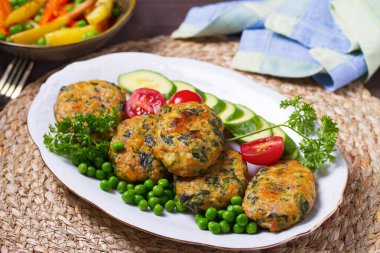 Kızarmış hindi ıspanak oval burger, yeşil bezelye ve salata.
