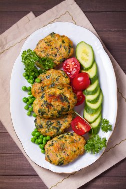 Kızarmış hindi ıspanaklı oval burger, yeşil bezelye ve salata. Yüksek açı görünümü