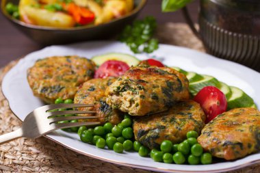 Kızarmış hindi ıspanak oval burger, yeşil bezelye ve salata.