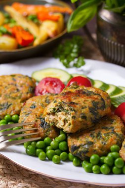 Kızarmış hindi ıspanak oval burger, yeşil bezelye ve salata.