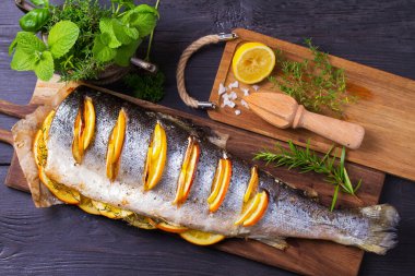 Servis güvertesinde tam pişmiş somon balığı. Yüksek açı görünümü