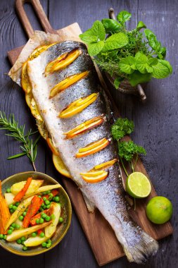 Servis güvertesinde tam pişmiş somon balığı. Yüksek açı görünümü