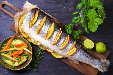 Servis güvertesinde tam pişmiş somon balığı. Yüksek açı görünümü