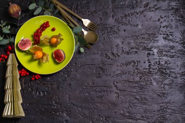 Tabak, çatal bıçak, meyve ve okaliptüs içeren Noel kompozisyonu. Kış tatili ve şenlikli bir geçmiş. Yeni yıl yemeği. Kopyalama alanı olan üst görünüm