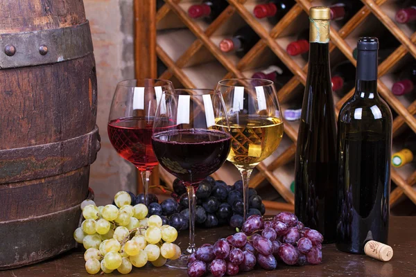 Bicchieri rossi, rosa e bianchi e bottiglie di vino — Foto Stock
