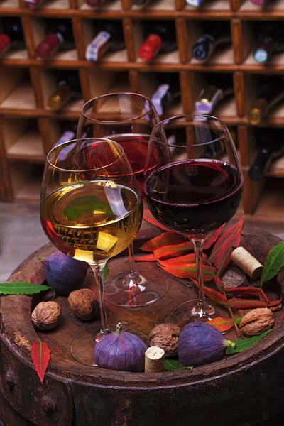 Bicchieri rossi, rosa e bianchi e bottiglie di vino — Foto Stock