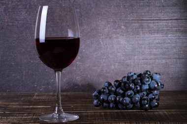 Bardak kırmızı şarap, peynir, üzüm, ceviz, incir, Erik ve elma ahşap arka plan üzerinde