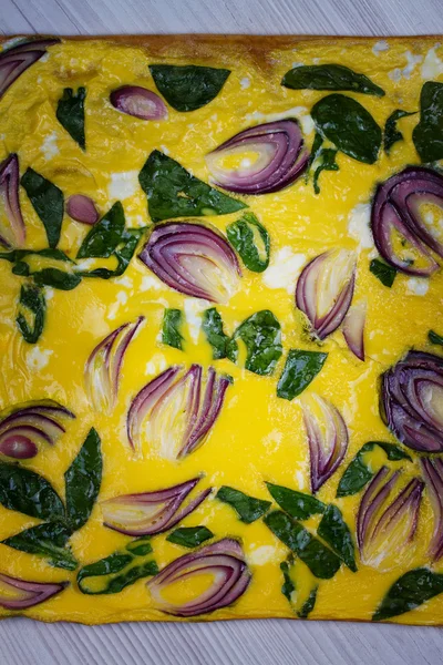 Omelette avec oignon bleu et épinards sur parchemin — Photo