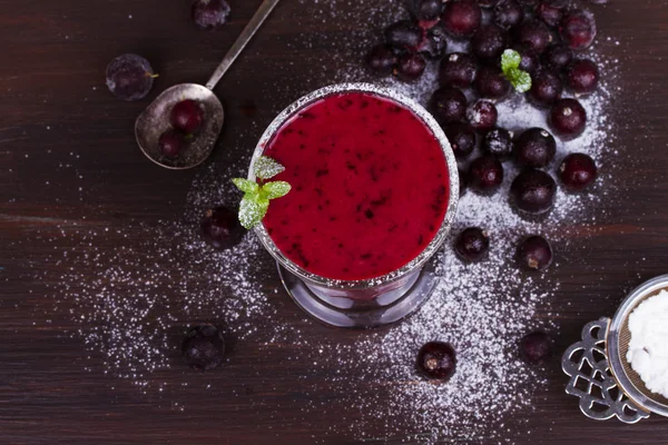 Batido de bayas de verano congelado adornado con menta sobre fondo de madera oscura — Foto de Stock