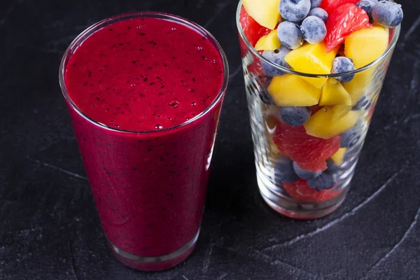 Smoothie à la mangue, au pamplemousse et aux myrtilles. Salade de fruits frais. Des tranches de fruits. Vue d'en haut, prise de vue studio en haut — Photo