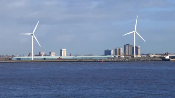 Un largo tiro estático de dos aerogeneradores en la orilla norte del río Mersey en Liverpool en un día soleado en otoño. — Vídeos de Stock