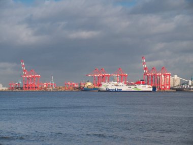Mersey Nehri 'nde Stena Feribotu, Kuzey İrlanda' daki Belfast 'a giden Liverpool Limanı' nın vinçlerini taşıyan konteynırı geçer. Kışın güneşli bir günde çekilmiş..