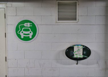 Elektrikli aracın (EV) şarj noktasındaki bir tabela arızalı olduğunu söylüyor. İngiliz ASDA süpermarketinin bir şubesinin otoparkında çekilmiş..