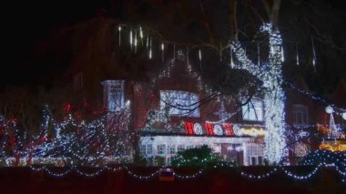 Statik, İngiltere 'nin kuzeybatısındaki bir evin ön ve bahçesini süsleyen büyük bir yılbaşı ışığı koleksiyonunun geniş gece görüntüsü..