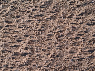 Güneşli bir günün sonunda batan güneşin gölgeleriyle çekilen rüzgar, Solway Sahili, Cumbria, İngiltere 'de kumları savurdu..