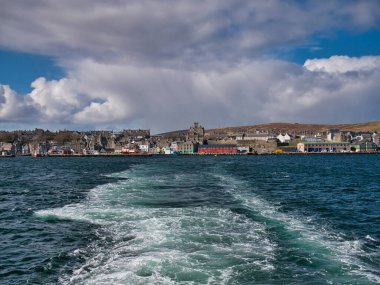 Bressay Sound 'un karşısında, Shetland Adaları' nın ana kasaba ve limanı Lerwick 'in mavi gökyüzü ve beyaz bulutlarla güneşli bir günde çekilmiş görüntüsü..