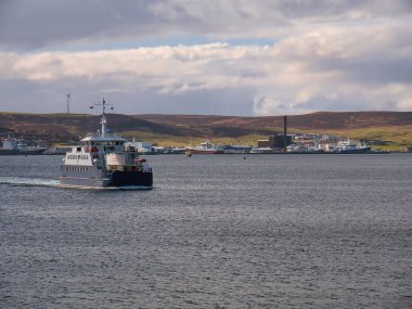 Holmsgarth Terminali ve Lerwick Limanı arka planda iken Fivla feribotu sakin ve bulutlu bir günde Lerwick 'ten Bressay' e hareket eder.