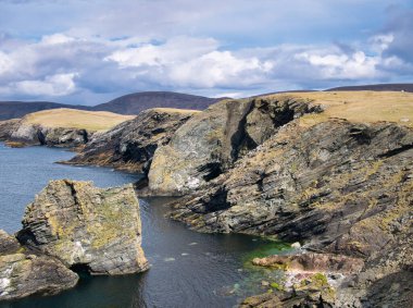 Kenna Ness, Shetland, İngiltere 'de kıyı kayalarının arasına yerleştirilmiş katman. İsimsiz bir volkanik saldırı, geç Silurian 'dan ilk Devonian' a - Felsic-rock. Cahil kaya 398 ila 423 milyon yıl önce oluştu..