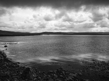 Lunna Ness, Shetland, İngiltere 'deki Outrabister' dan kara ve beyaz bir kıyı, deniz ve bulut manzarası.