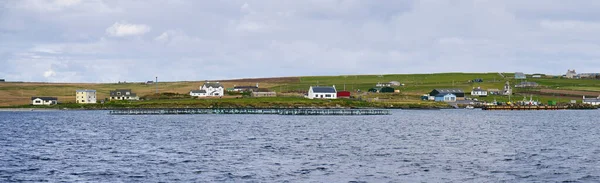 在英国设得兰的昂斯特岛南部 一个沿海社区 即维耶达德的沿海社区的全景 左边是养鱼笔 右边是港口 — 图库照片