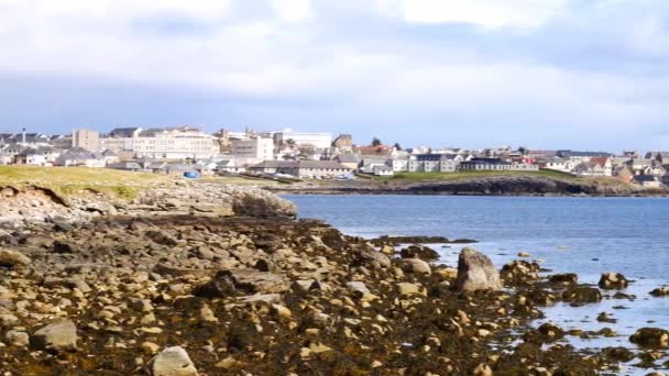 Desde el Ness of Sound a través de Brei Wick, una panorámica del horizonte de Lerwick, la principal ciudad y puerto de Shetland en el norte del Reino Unido. Tomado en un día soleado en primavera con cielo azul y nubes. — Vídeos de Stock