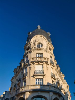 Vannes, Fransa - 30 Sep 2025: Fransa 'nın Vannes kentindeki Au Progres binasının süslü köşe kubbesi ve taş cephesi, sabah güneşiyle aydınlanan derin mavi gökyüzü.