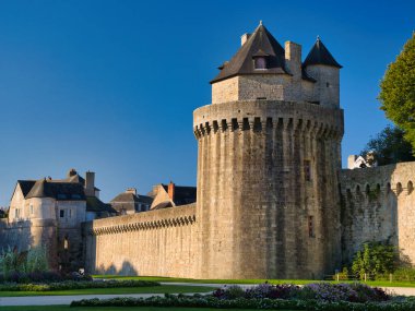 Vannes, Fransa - 30 Sep 2025: Güneşli ortaçağ surları ve Vannes, Morbihan, Brittany, Fransa 'daki eski kentin yuvarlak kulesi, aşağıdaki bahçeleri ve derin mavi gökyüzü.
