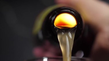 Bira şişeden dökülür, şişe içeriden parlar. yavaş çekimde 180 fps