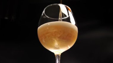 Az köpüklü biranın döküldüğü cam kadehin yakın çekimi. Baloncukların altın renginde parıldadığı temiz bir kupanın detaylı bir alt görüntüsü. stüdyo