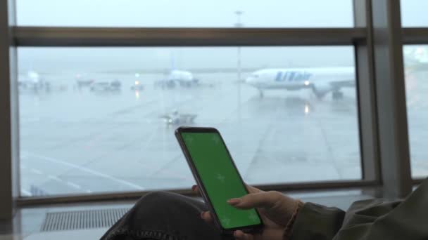 Flicka Sitter Och Använder Smartphone Med Grön Skärm Flygplatsen Stora — Stockvideo