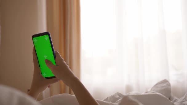 Menina Deitada Cama Usa Smartphone Com Uma Tela Verde Sol — Vídeo de Stock