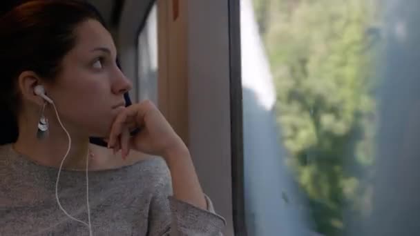 Mladá Dívka Tmavými Vlasy Sedí Vlaku Okna Poslouchá Hudbu Okna — Stock video
