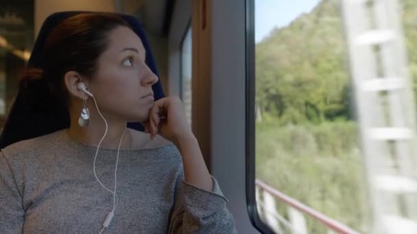 Uma Jovem Com Cabelo Escuro Senta Trem Perto Janela Ouve — Vídeo de Stock